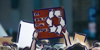 Eine Gruppe von Menschen hält ein Slogan HuT-naher Gruppierungen „Das Kalifat ist die Lösung“ hoch.  